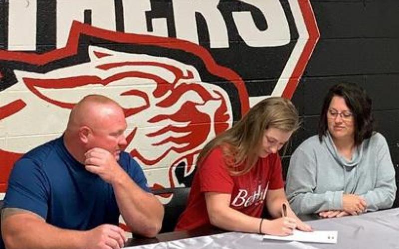 Concordia High School senior Katlynn Miller, middle, signs a basketball letter-of-intent with Bethel College on Monday. Also pictured are Miller’s mother, Kathy, right, and father, Tony.